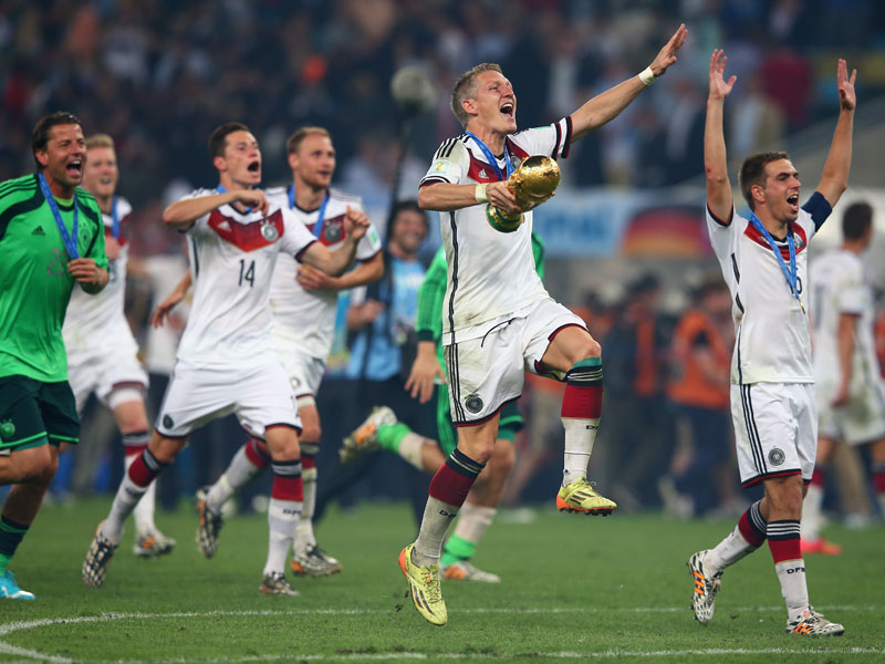 Jubelsprung: Bastian Schweinsteiger mit dem WM-Pokal.
