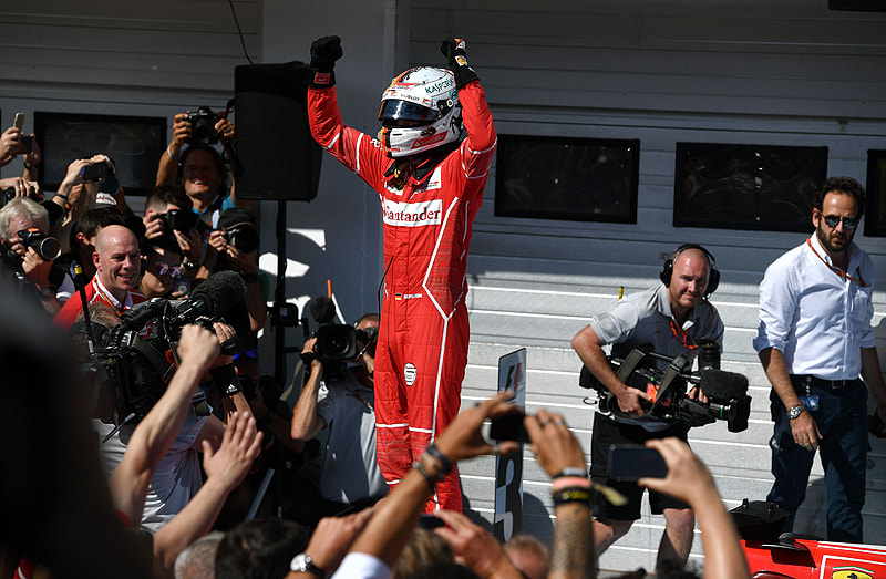 Sebastian Vettel feiert in Ungarn auf seinem Ferrari stehend seinen vierten Saisonsieg. 