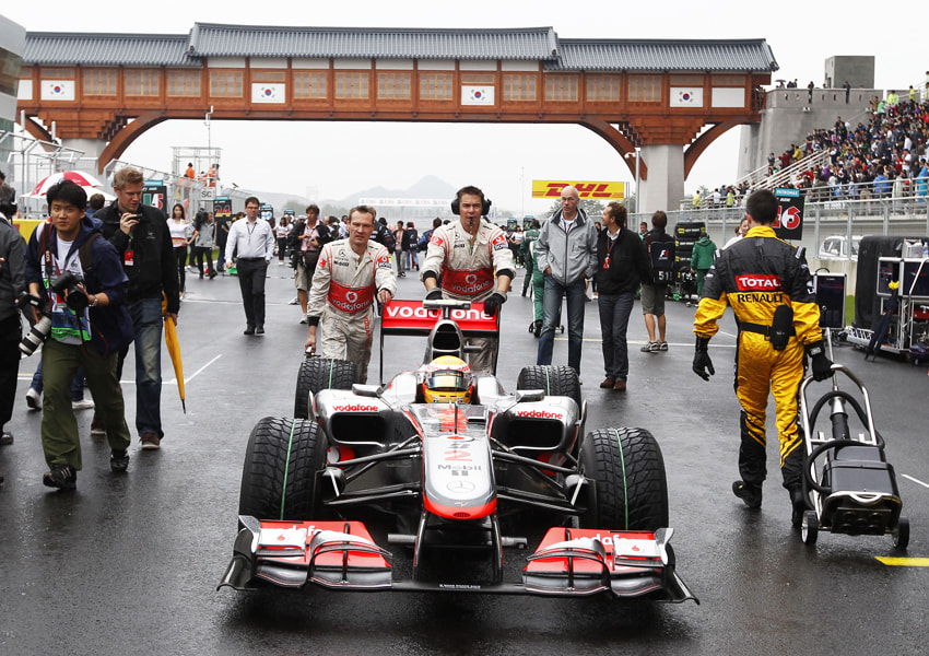 Lewis Hamilton wird von McLaren-Mechanikern in die Startaufstellung geschoben. 