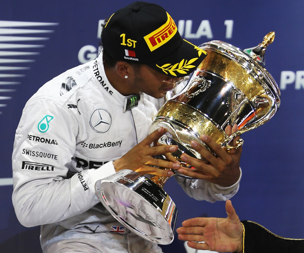 Bahrain-Sieger Lewis Hamilton in inniger Umarmung mit der Siegertroph&#228;e.