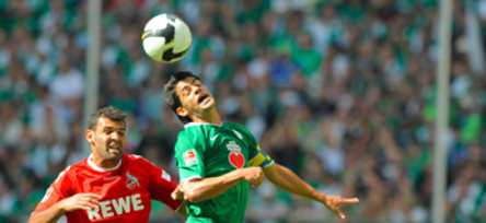 Wolfsburgs Josué gewinnt ein Kopfballduell gegen Kölns Antar (li.).