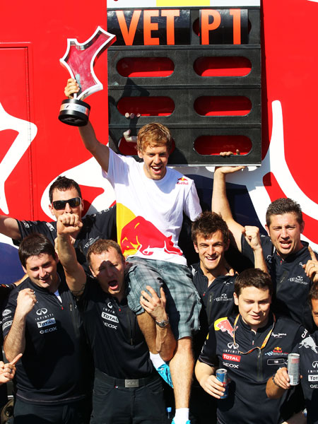 Sebastian Vettel reckt den Siegerpokal in die H&#246;he