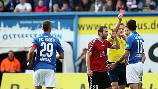 Schiedsrichter Sven Waschitzki zeigt Rostocks Dennis Erdmann (re.) die Rote Karte.