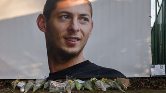 Ein Plakat mit dem Konterfei von Emiliano Sala am Trainingsgelände des FC Nantes. Fans haben Blumen niedergelegt.