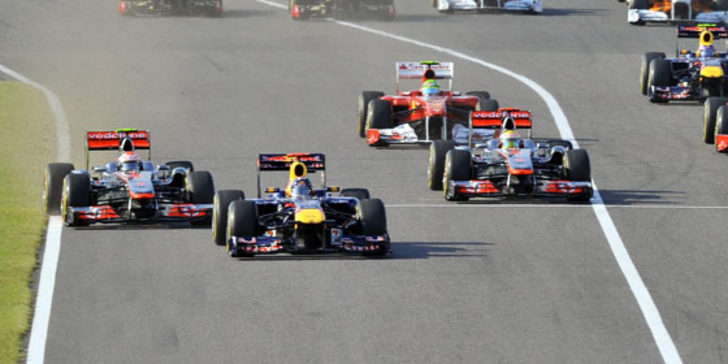Der Start: Sebastian Vettel (Mitte) behauptet sich mit einem harten Manöver gegen Jenson Button.