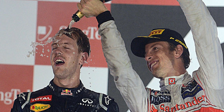 Abkühlung in der Sauna Singapur: Jenson Button verpasst Sieger Sebastian Vettel die gebührende Dusche.
