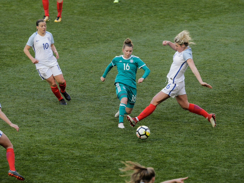 Linda Dallmann umringt von englischen Gegenspielerinnen.