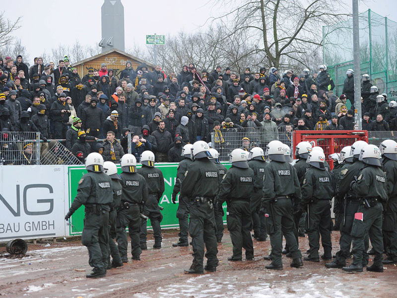 Polizisten ziehen vor dem Dresdner Block in M&#252;nster auf. Im Hintergrund ist der Zaun besch&#228;digt.