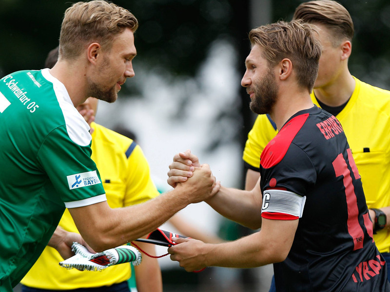 Darf auch in der kommenden Saison vor dem Spiel den Wimpel austauschen: RWE-Kapit&#228;n Sebastian Tyrala (rechts).
