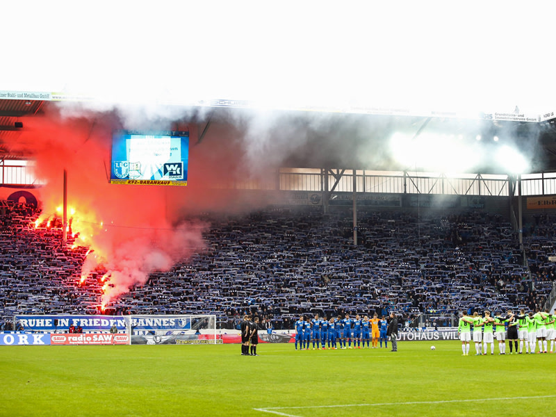 Vor dem Spiel brennen Magdeburger Fans w&#228;hrend einer Gedenkminute Pyrotechnik ab.