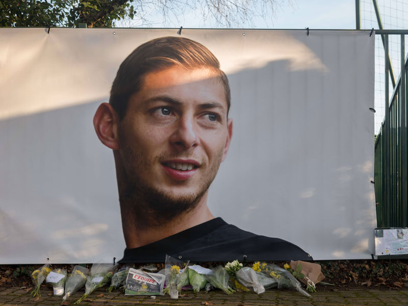 Ein Plakat mit dem Konterfei von Emiliano Sala am Trainingsgel&#228;nde des FC Nantes. Fans haben Blumen niedergelegt.