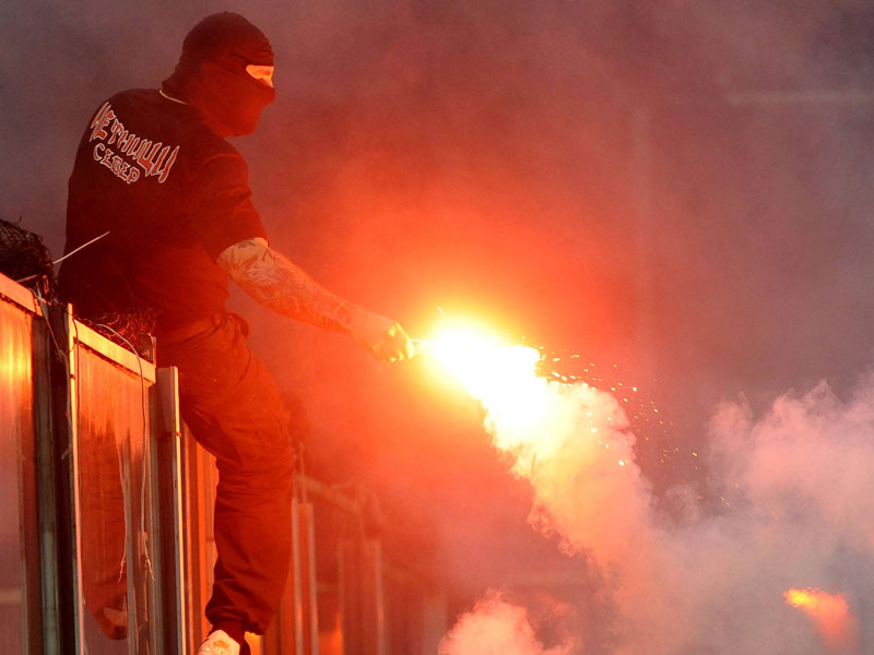 Ein serbischer Hooligan in Genua beim Abbrennen eines Feuerwerksk&#246;rpers.