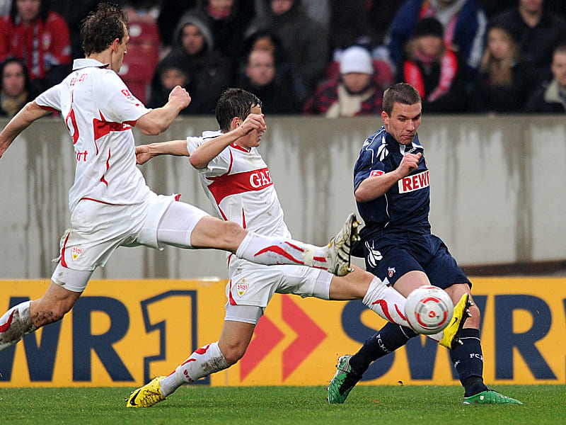 Podolski flankt, zwei Stuttgarter werfen sich in den ball.