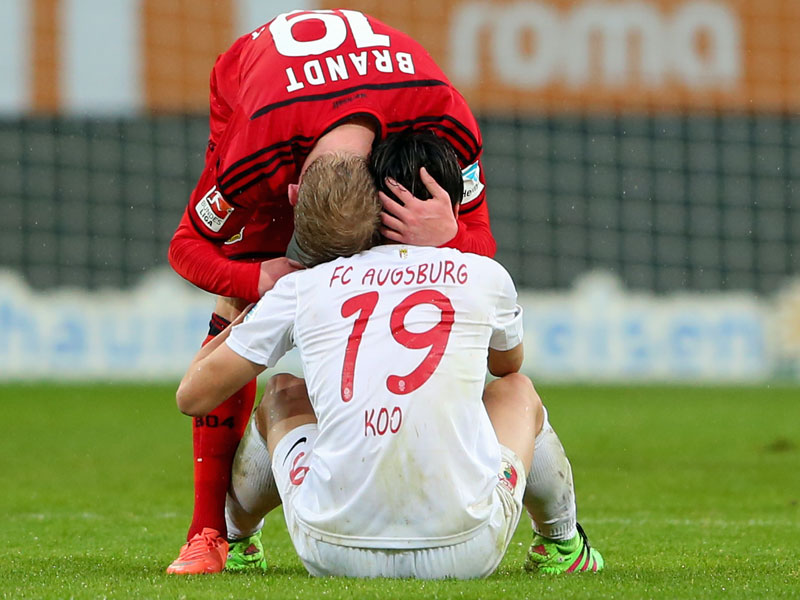 Leverkusens Julian Brandt tr&#246;stet Augsburgs Ja-Cheol Koo.
