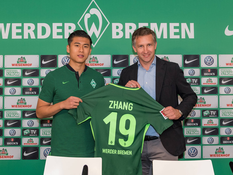 Die Nummer 19 f&#252;r den Neuzugang: Yuning Zhang mit Bremens Sportchef Frank Baumann.