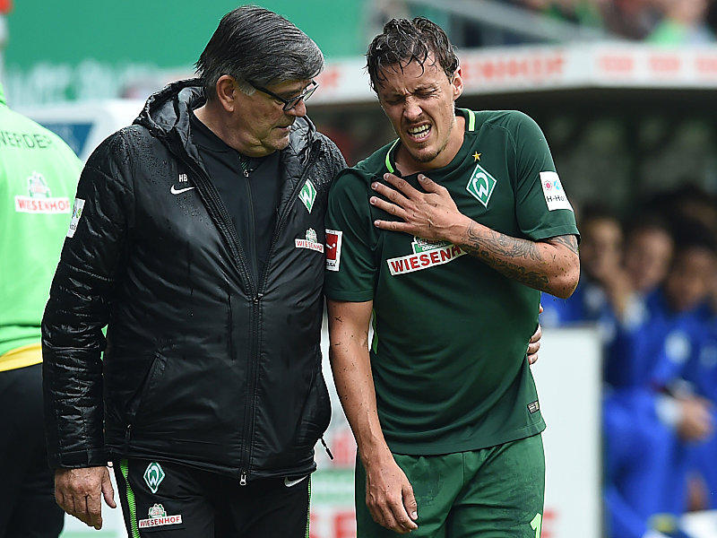 Werders Physiotherapeut Holger Berger hilft Max Kruse auf dem Weg in den Innenraum. 