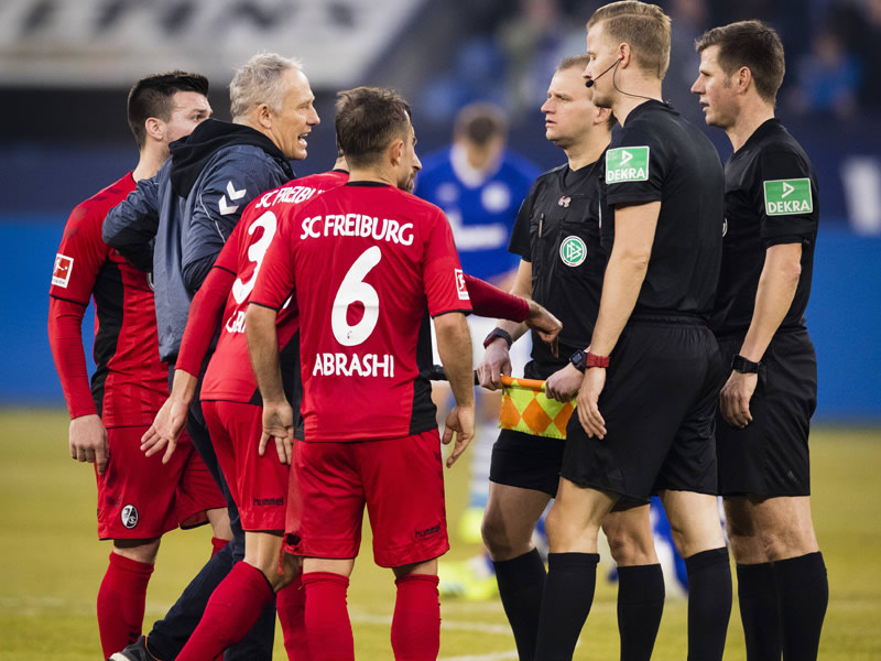 Redebedarf nach dem Spiel auf Schalke: Freiburgs Trainer Christian Streich (2.v.l.) und Schiedsrichter Frank Willenborg (r.).