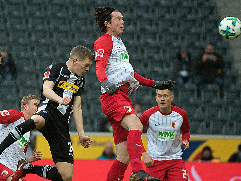Gladbachs Matthias Ginter köpft vor Augsburgs Michael Gregoritsch zur Führung ein.