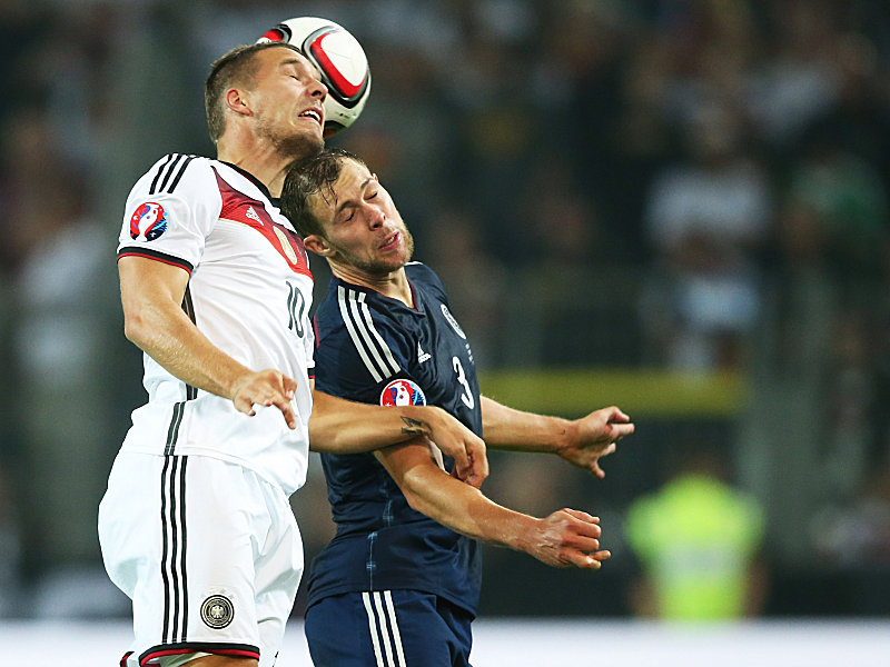 Intensives Duell: Lukas Podolski im Zweikampf mit Schottlands Steven Whittaker (re.).