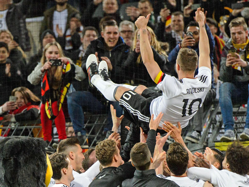 Lukas Podolski l&#228;sst sich nach dem Schlusspfiff von allen feiern.