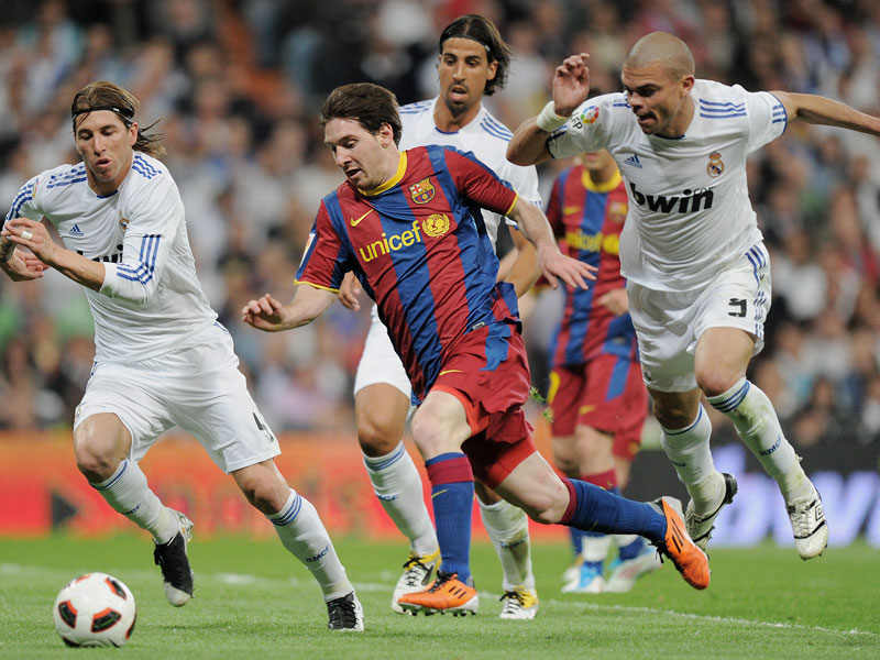 Lionel Messi nimmt es gleich mit drei Gegenspielern auf, unter anderem auch mit Sami Khedira (Mi.).