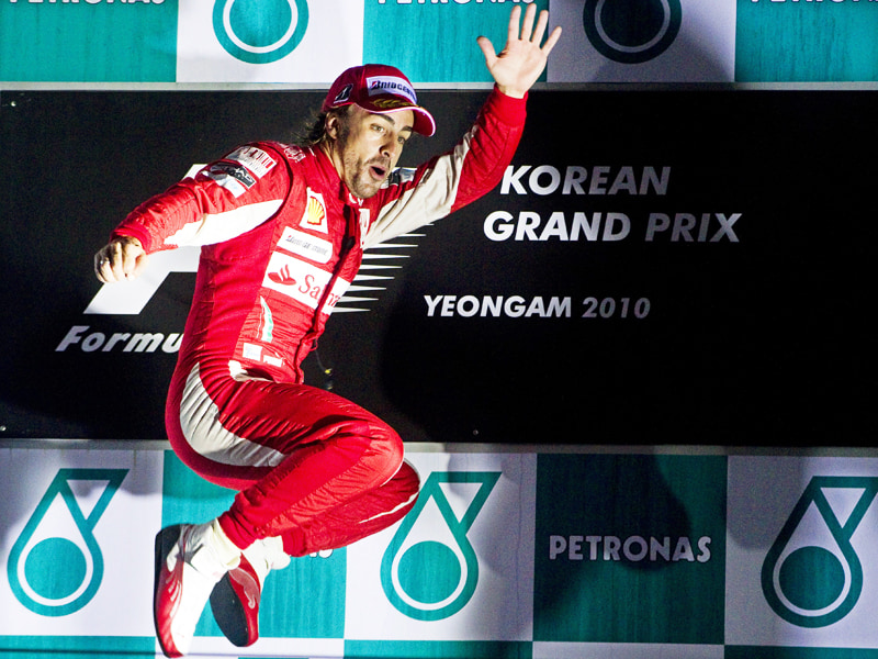 Strahlender und springender Sieger: Ferrari-Pilot Fernando Alonso auf dem Podium in S&#252;dkorea. 