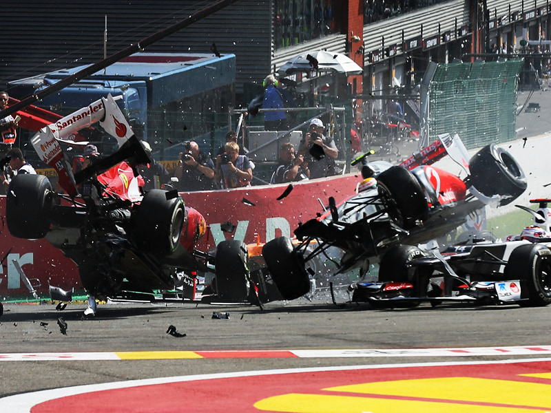 Startunfall: Hamilton und Alonso (li.) fliegen mit ihren Boliden durch die Luft.