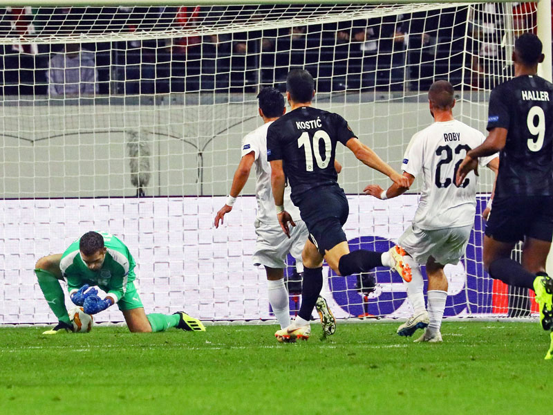 Schuss durch die Hosenträger: Frankfurts Filip Kostic (M.) schießt, Apollons Keeper Bruno Vale lässt den Ball durch Arme und Beine rutschen.