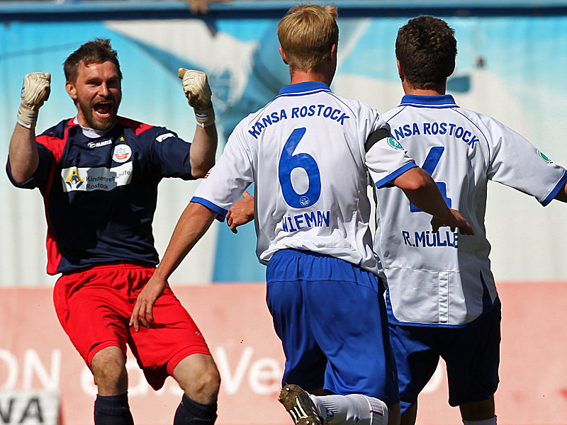 Die Spielkameraden Jörg Hahnel und Michael Wiemann freuen sich mit Robert Müller, der durch seinen Siegtreffer das Tor zu Liga zwei für Hansa weit aufstieß (von links nach rechts).
