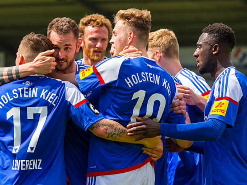 Die Spieler von Holstein Kiel bejubeln den 3:0-Heimsieg gegen den Halleschen FC.