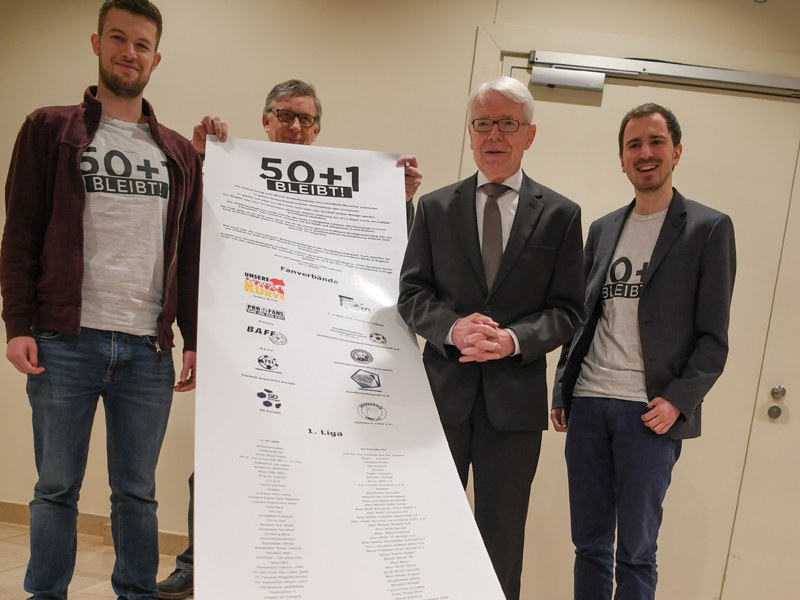 DFL-Präsident Reinhard Rauball (2.v.r.) bekommt eine Erklärung der Fans für den Erhalt der 50+1-Regel.