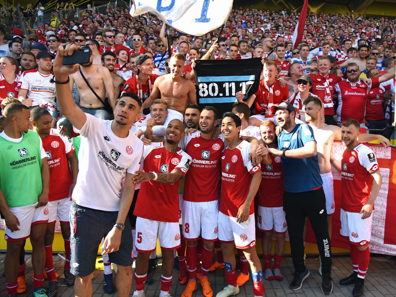 Selfie für den Klassenerhalt: Leon Balogun (mit Handy) und seine Mainzer genießen den Sieg in Dortmund.
