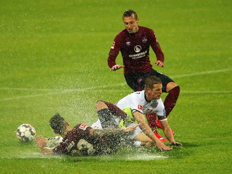 Viel Wasser, kein Ball: Nürnbergs Tim Leibold (li.) und Adam Zrelak (re.) im Duell mit Leverkusens Lars Bender.