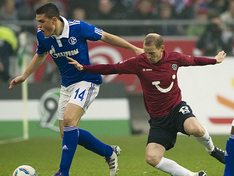 Ausrutscher: Hannovers Schlaudraff gegen Papadopoulos (li.).