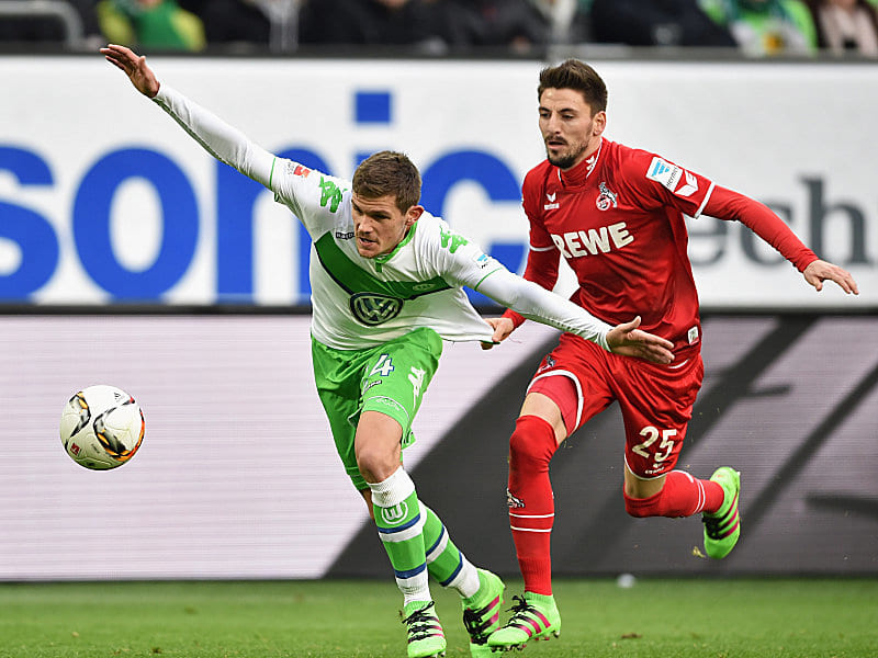 Auf der Jagd nach dem Ball: Wolfsburgs Sebastian Jung und Kölns Filip Mladenovic (re.).