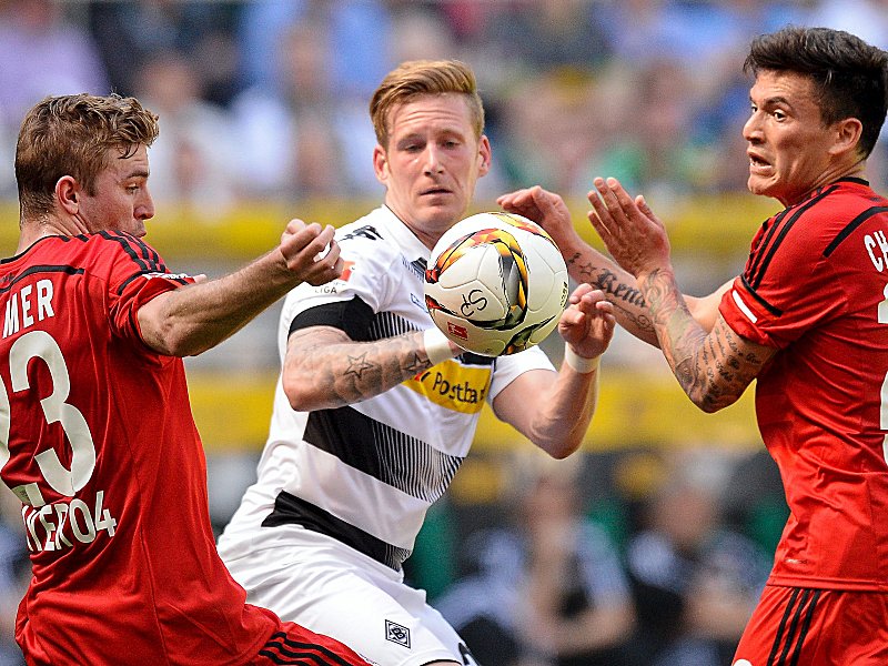 Der Ball im Fokus: André Hahn sowie die Bayer-Spieler Christoph Kramer (l.) und Juan Aranguiz (r.).