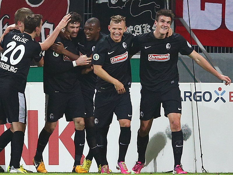 Matchwinner: Daniel Caligiuri wird von seinen Freiburger Teamkollegen geherzt.