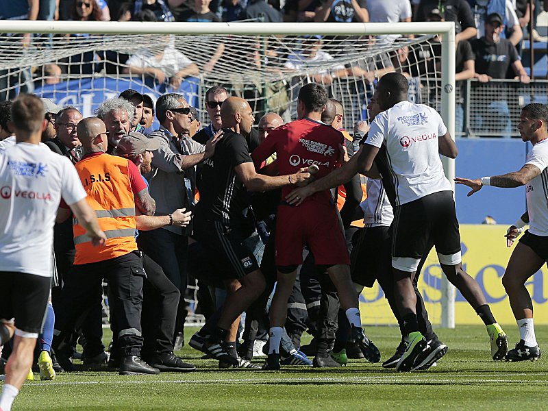 Unschöne Szenen in Bastia: Lyons Spieler und Ordnungskräfte stemmen sich den Fans entgegen.