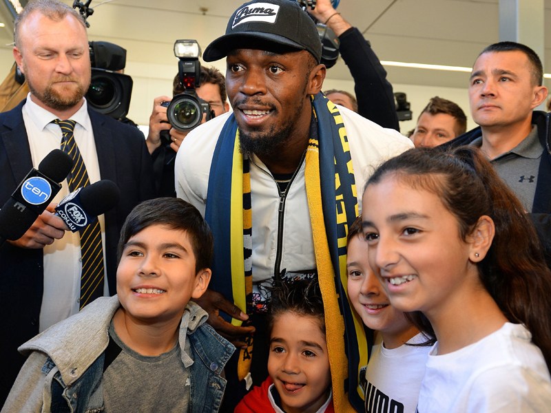 Ein erstes Lächeln für die Kameras: Usain Bolt nach seiner Ankunft in Sydney.