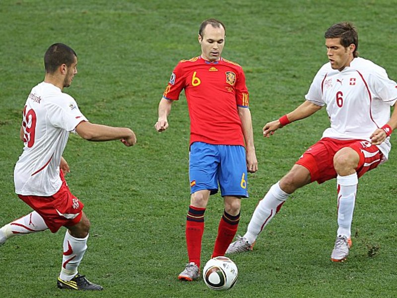 Iniesta wird von Derdiyok und Huggel in die Mangel genommen.