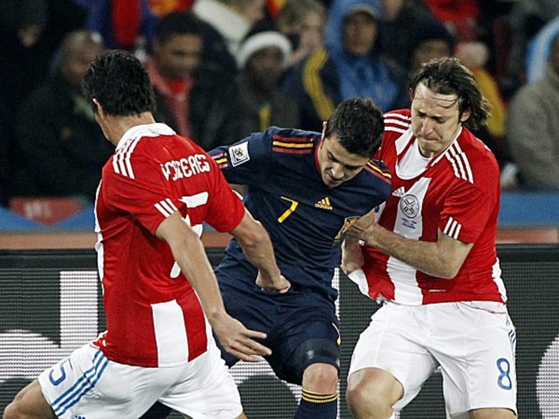 Spaniens David Villa wird von Viktor Caceres und Edgar Barreto (re.) in die Mangel genommen.