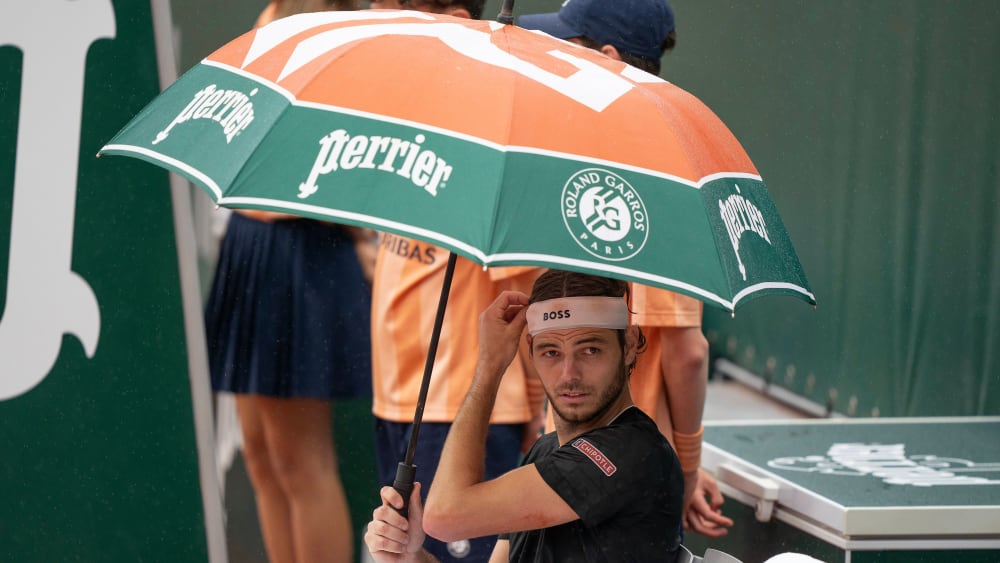 Der US-Amerikaner Taylor Fritz schützt sich mit einem schicken Schirm vor dem Regen bei den French Open.