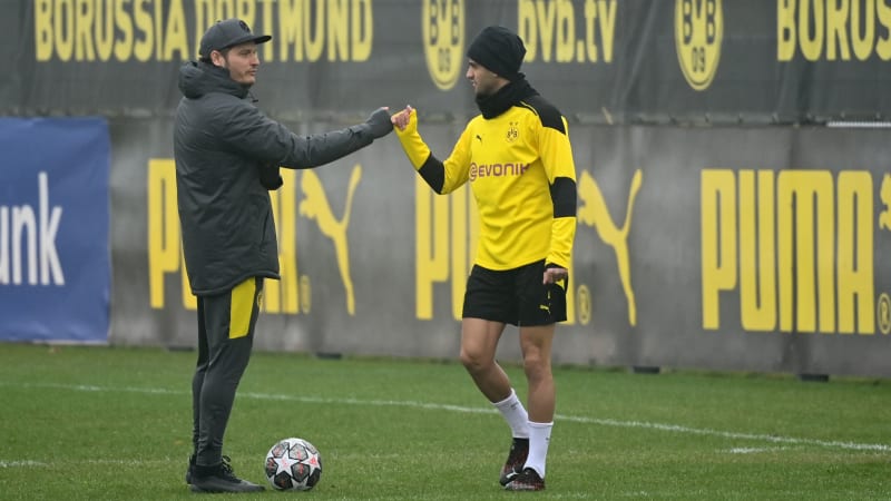 Dortmund's coach Edin Terzic (L) and Dortmund's German midfielder Mahmoud Dahoud (R) make a fist bump as they arrive for a training session on the eve of the Champions League - Last 16 Second Leg football match between Borussia Dortmund (Germany) and Sevilla (Spain) at the team's training ground in Dortmund, western Germany on March 8, 2021. (Photo by Ina FASSBENDER / AFP) (Photo by INA FASSBENDER/AFP via Getty Images)