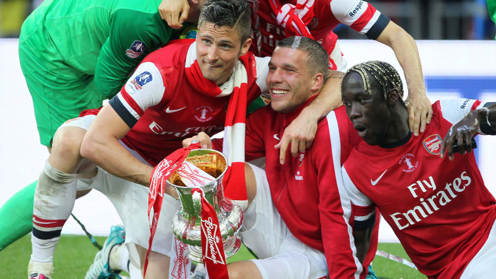 Lukas Podolski (Mi.) jubelt mit seinen Teamkollegen beim FC Arsenal