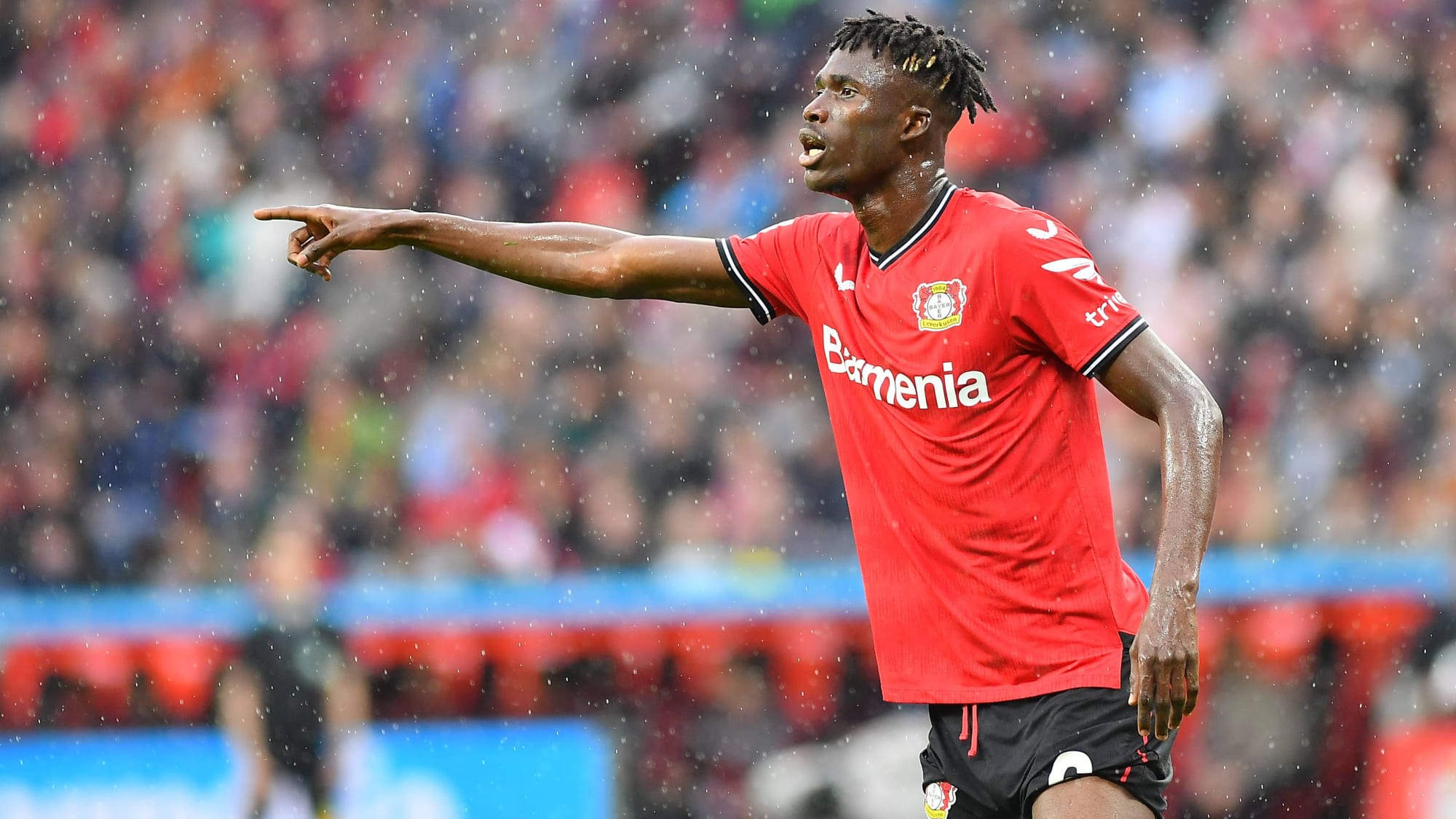 Odilon Kossounou (Bayer Leverkusen) dirigiert mit der rechten Hand