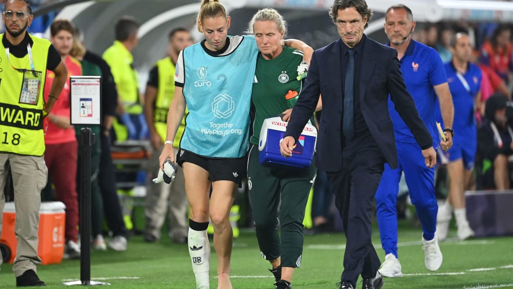 Die verletzte Sarai Linder wird von einer Betreuerin gestützt, rechts Frankreichs Nationalcoach Laurent Bonadei.