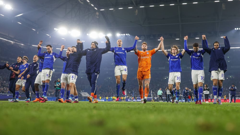 Beste Laune: Die Schalker Mannschaft lässt sich nach dem ergatterten Derby-Punkt von den Fans feiern.