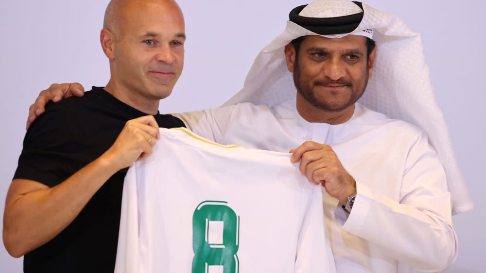 Andres Iniesta (li.) hält sein neues Trikot bei Emirates Ras Al-Khaima hoch - natürlich mit der Nummer 8.