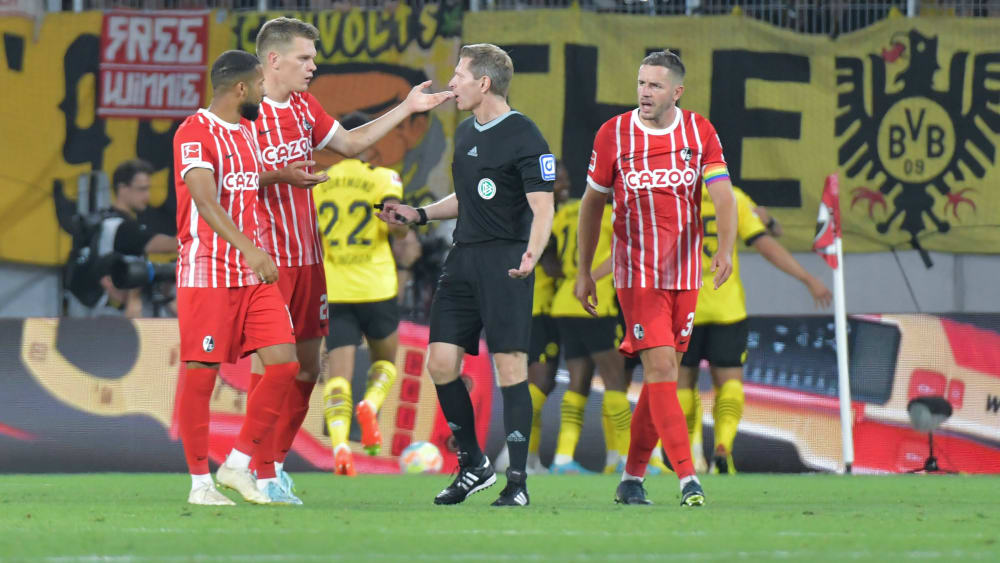 Diskussionsbedarf: Die Freiburger Spieler reden auf Referee Tobias Welz ein.