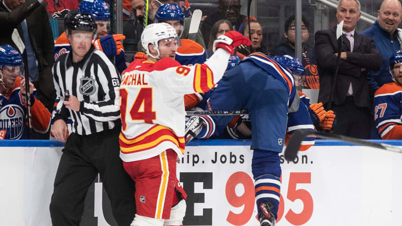 Calgary Flames' Brayden Pachal (94) checks Edmonton Oilers' Corey Perry (90) during second period NHL action in Edmonton, Alberta, Sunday, Oct. 13, 2024. (Jason Franson/The Canadian Press via AP)